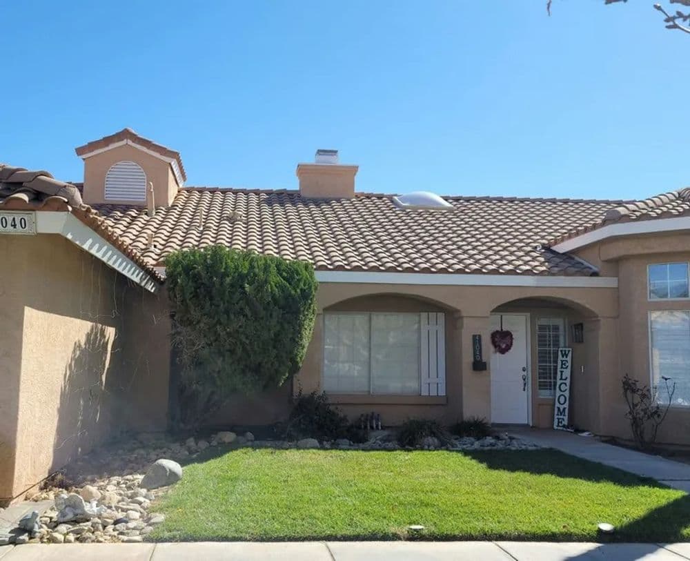 Single-story home with a tiled roof, welcoming entryway, and well-maintained front lawn.