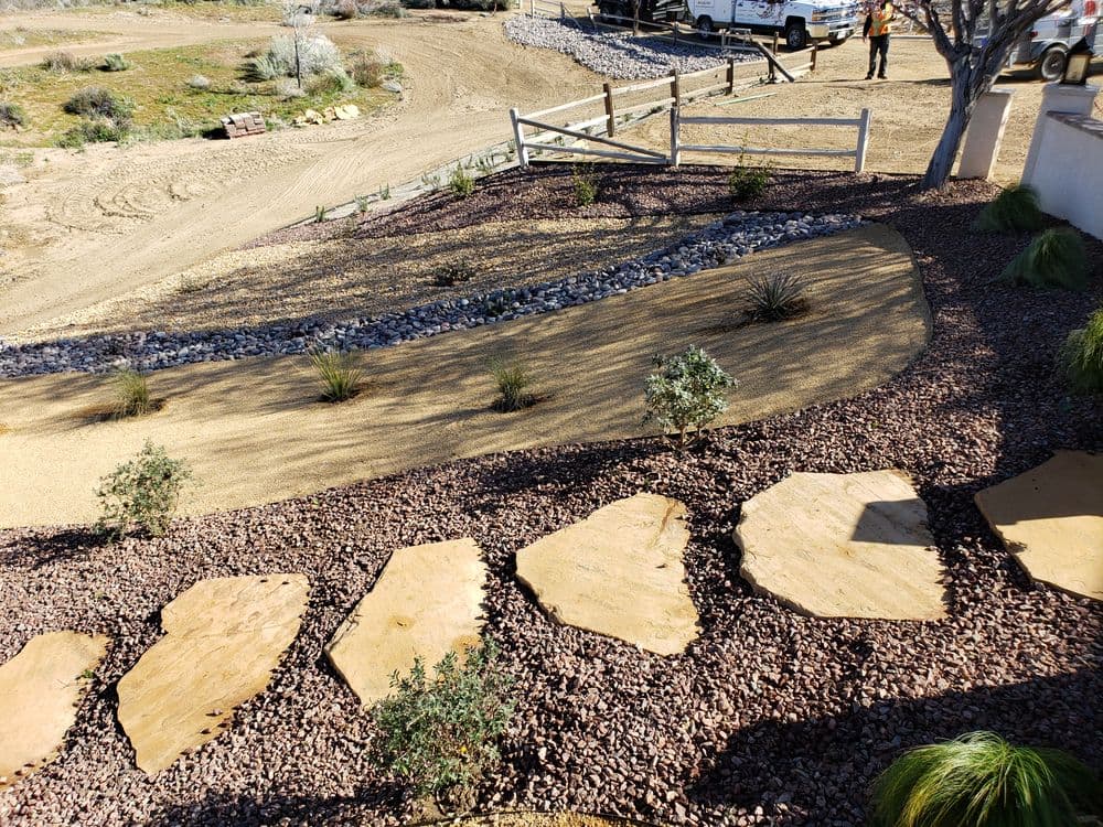 Desert landscape design with stone pathway, gravel, and drought-resistant plants.