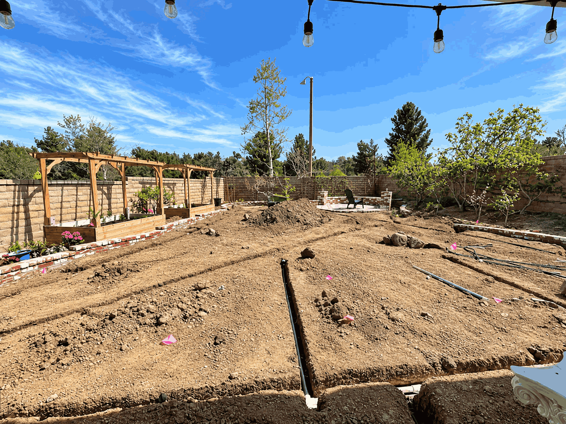 A backyard featuring a dirt floor surrounded by a wooden fence, creating an enclosed outdoor space.