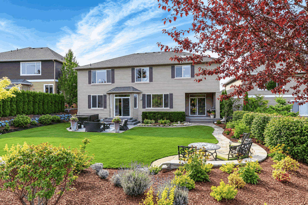 A picturesque yard showcasing a vibrant lawn and a variety of trees providing shade.