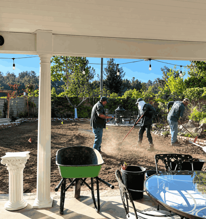 A diverse group of individuals collaborating on landscaping and gardening tasks in a backyard setting.
